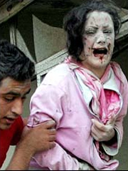 A Lebanese woman wounded in Israeli air strikes is helped from a building devastated in the attack on Tyre, Lebanon (July 16, 2006.) 